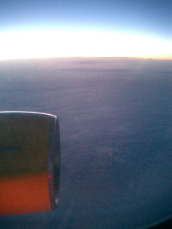Blick aus dem Fenster (die rote Unterseite des Triebwerks kommt von dem roten Positionslicht des Flugzeuges